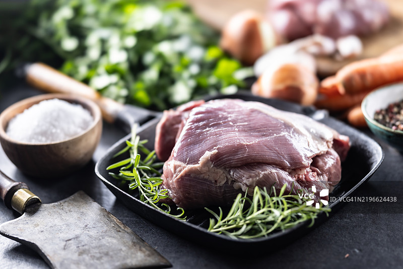 生火鸡大腿放在锅上，撒上迷迭香，准备烘烤图片素材