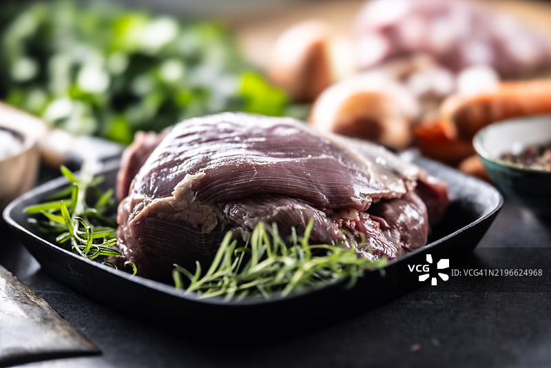 生火鸡大腿放在锅上，撒上迷迭香，准备烘烤图片素材