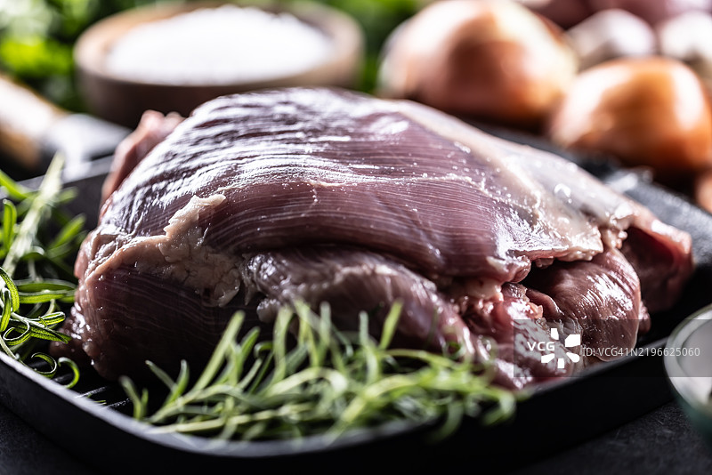 生火鸡大腿放在锅上，撒上迷迭香，准备烘烤图片素材