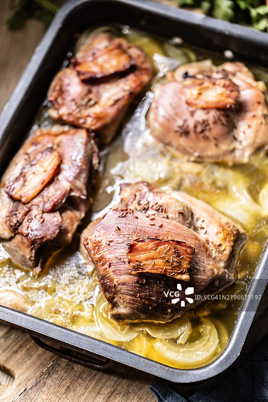 烤火鸡腿在烤盘上，配有培根和孜然洋葱酱图片素材