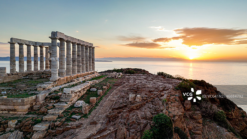 海神庙在苏尼翁角的日落时分的鸟瞰图，展示了被爱琴海环绕的标志性古希腊建筑，作为历史和文化地标，非常适合遗产和旅游主题。图片素材