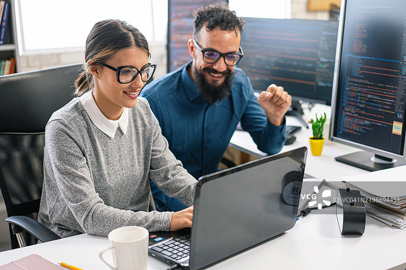 一对情侣，软件工程师在办公室一起使用电脑进行程序编码。编程语言开发技术，自由职业概念。图片素材