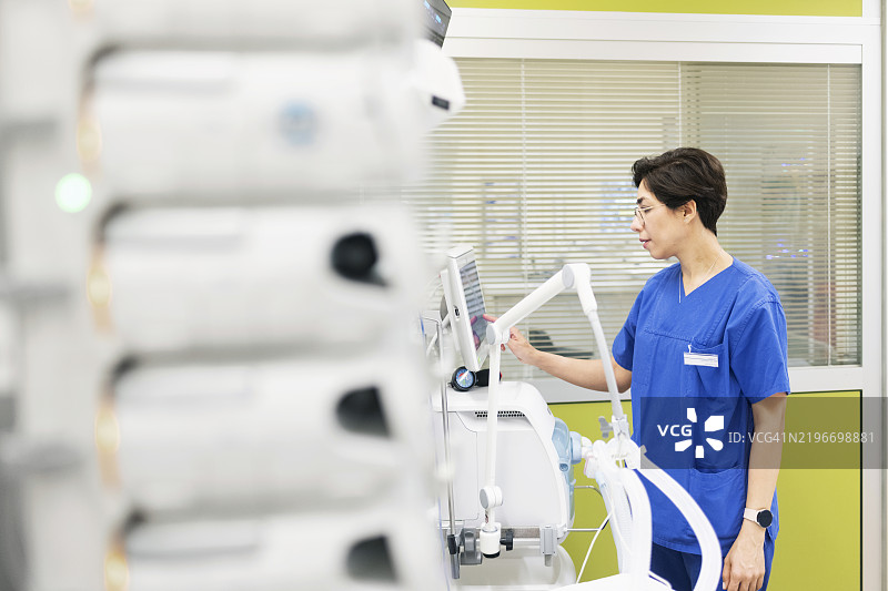 女麻醉师在重症监护室检查医疗呼吸机图片素材