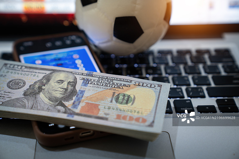 为自己喜欢的球队加油，并在博彩公司网站上下注。概念，在线足球博彩概念图片素材