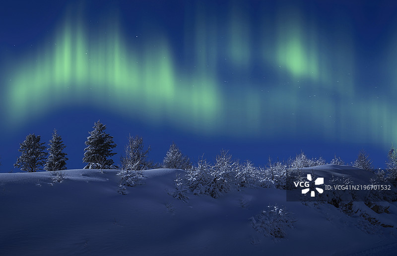 北极光照耀下的雪地风景。图片素材