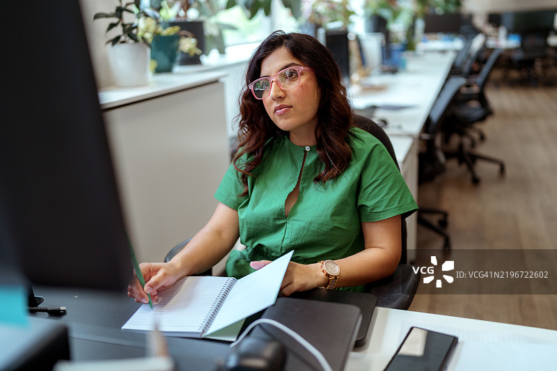 穿着得体的女商人在现代办公室工作图片素材