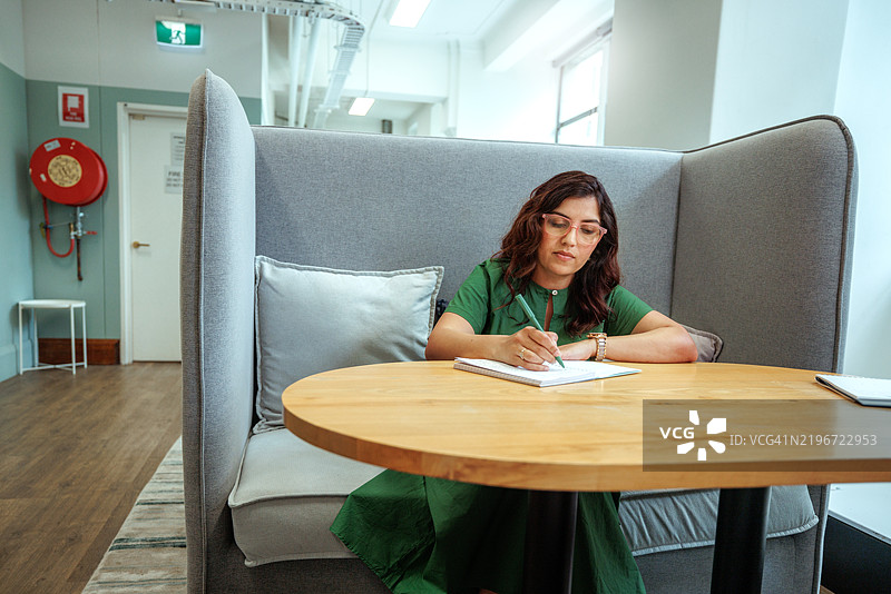 女商人在现代办公室工作时做笔记图片素材