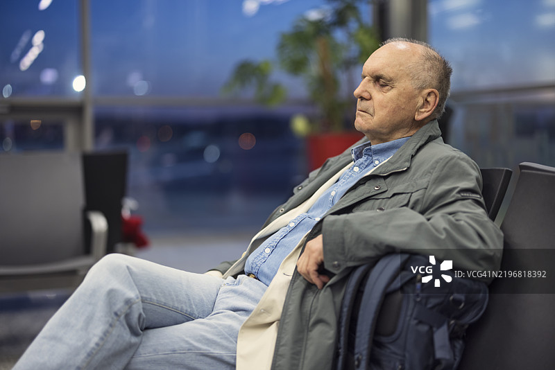老年人在机场等候飞机时小憩。图片素材