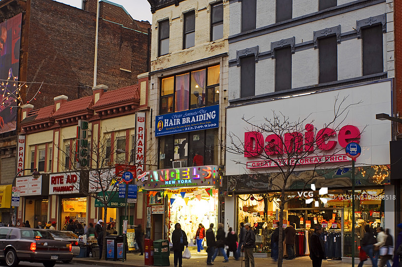 纽约市曼哈顿西哈莱姆125街的商家和行人。图片素材