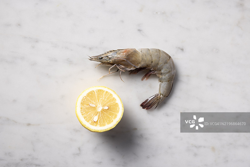 生虾和柠檬装饰的特写，背景为大理石。图片素材