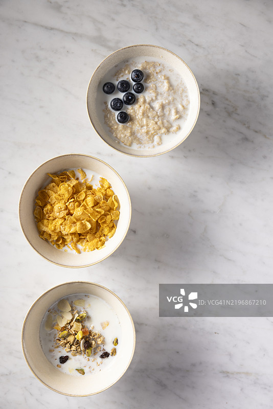 各种早餐的俯视图，包含玉米片、燕麦粥和麦片。图片素材