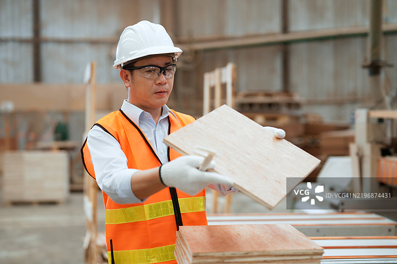 工厂主管在工业车间检查木板的质量控制图片素材