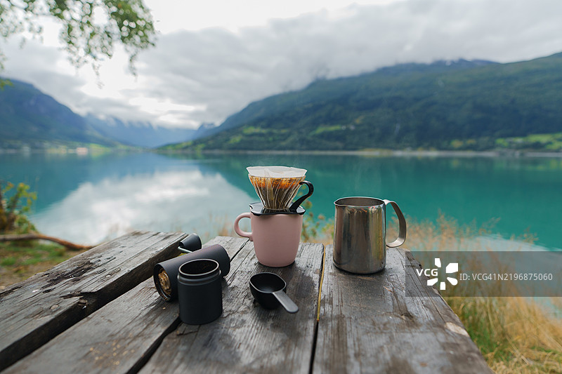 在湖泊背景下冲泡新鲜研磨的手冲咖啡图片素材