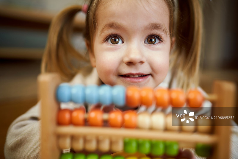 快乐的小女孩在玩算盘图片素材