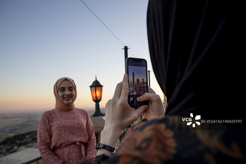 两个年轻女孩在旅游胜地马尔丁互相拍照图片素材