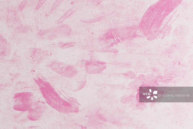 明亮的粉红色手印和指纹图案在纹理表面上图片素材