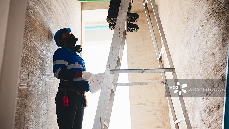 建筑工人站在铝制楼梯上图片素材