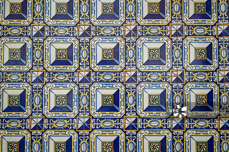 五彩缤纷的复古陶瓷砖形成重复的图案，装饰着墙壁或地板。图片素材
