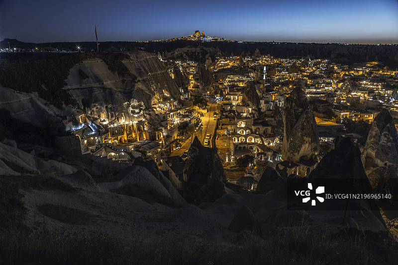土耳其卡帕多奇亚格雷梅夜景，灯光照亮的洞穴住宅和仙女烟囱。图片素材