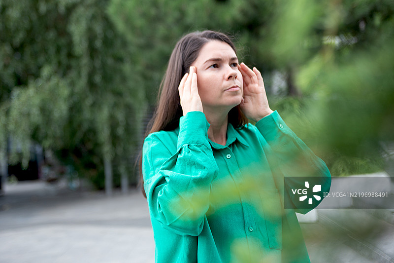 街头一位女性正在经历头痛或偏头痛的摄影作品。图片素材