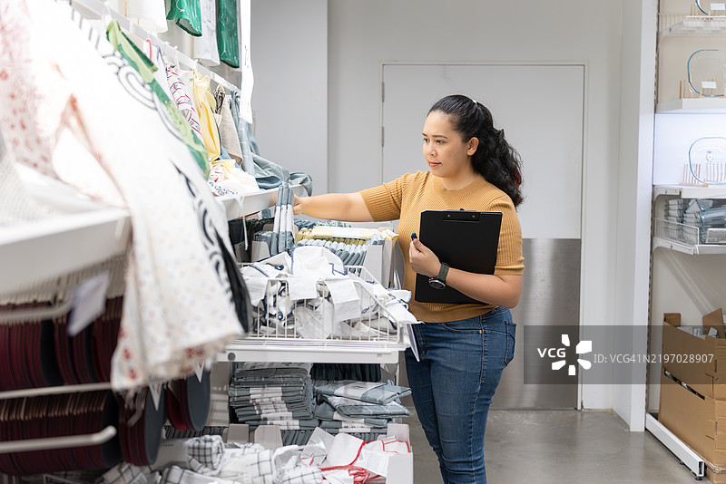 亚洲中年店主整理家居用品库存图片素材