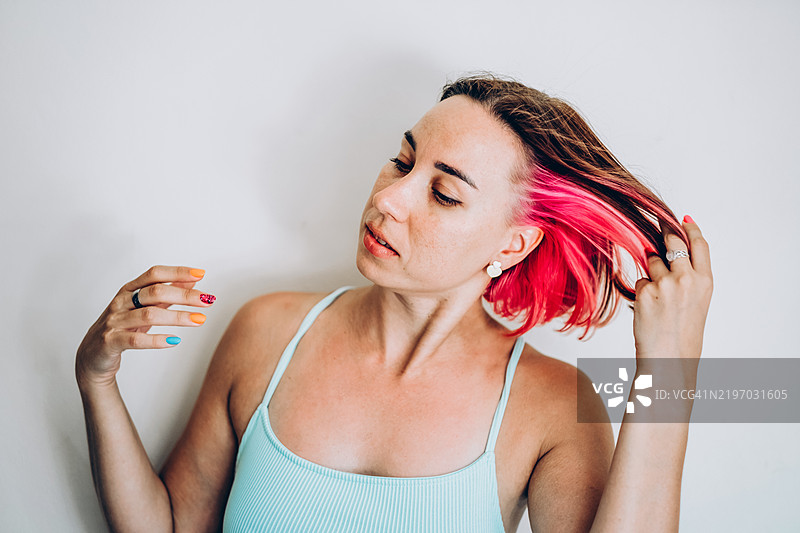 时尚的千禧一代年轻女性，双子座染发，开心地摇头图片素材