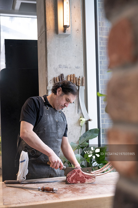 屠夫在切割战斧牛排图片素材