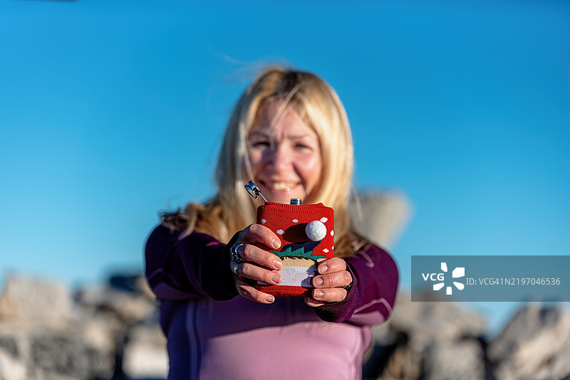 一位女性在晴朗的天空下户外手持节日水壶的特写镜头图片素材