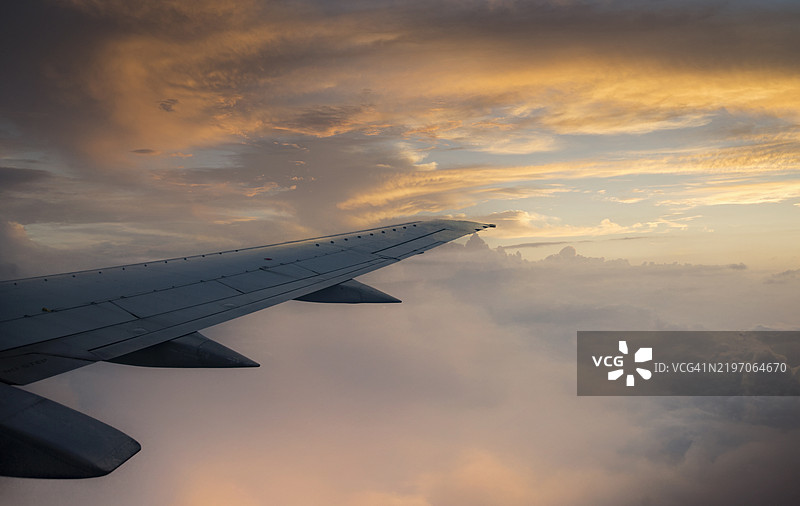 飞机机翼在多云的天空上。图片素材