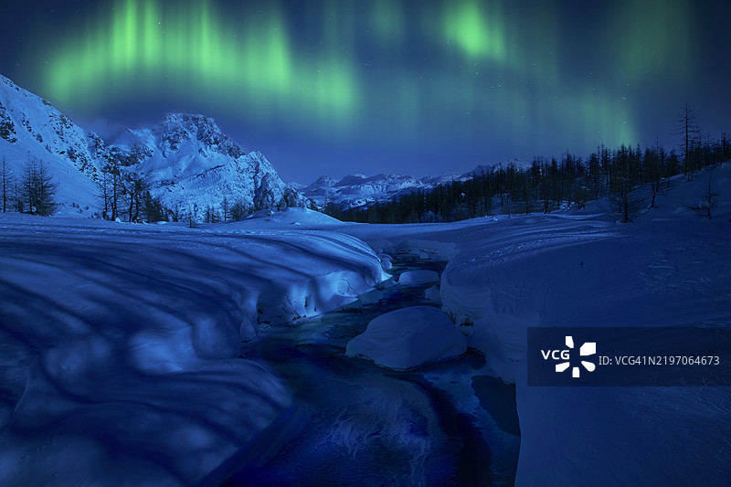 北极光（极光）照耀在雪-covered的景观上。图片素材