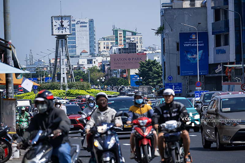 越南胡志明市夜晚，电动车和摩托车在奠边府路上排成密集的交通。图片素材