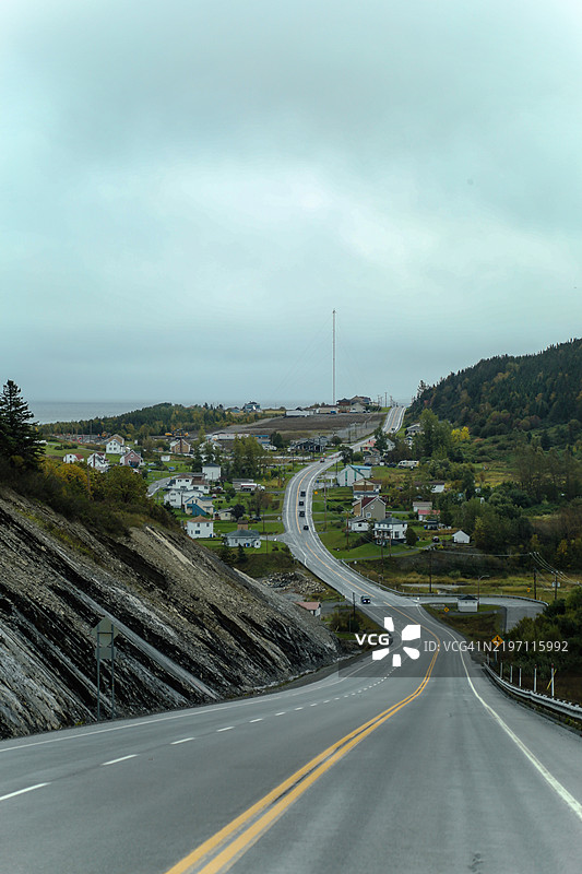 在魁北克的加斯佩半岛，穿过被森林环绕的小乡村的公路驾驶图片素材