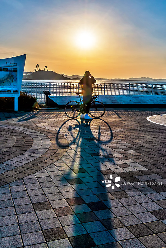 一名骑自行车的人在拍摄日落图片素材