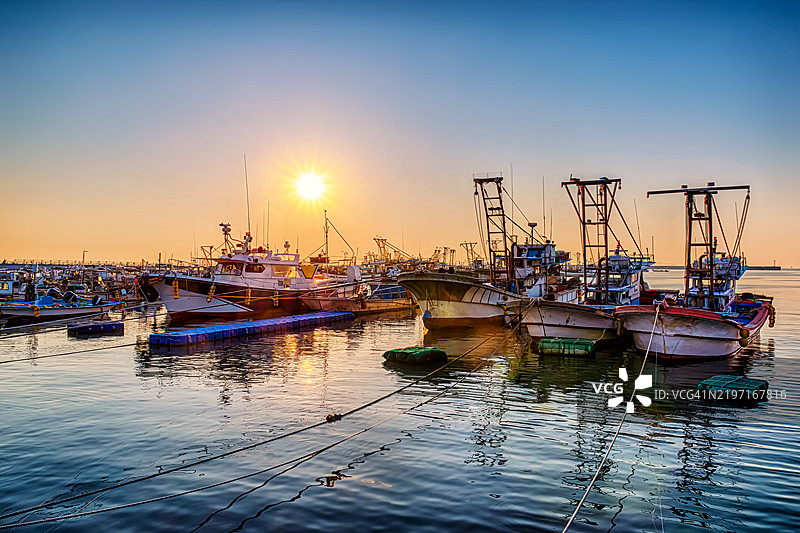 港口的渔船在绚丽的日落天空下图片素材