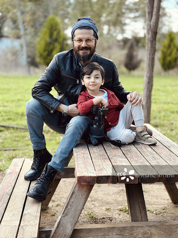 年轻父亲和小儿子手持相机的肖像图片素材