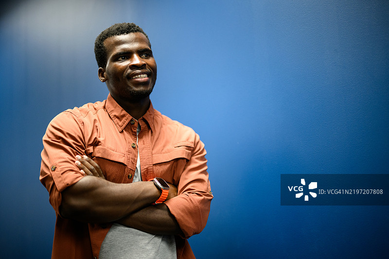 自信的年轻男子蓝色背景肖像图片素材