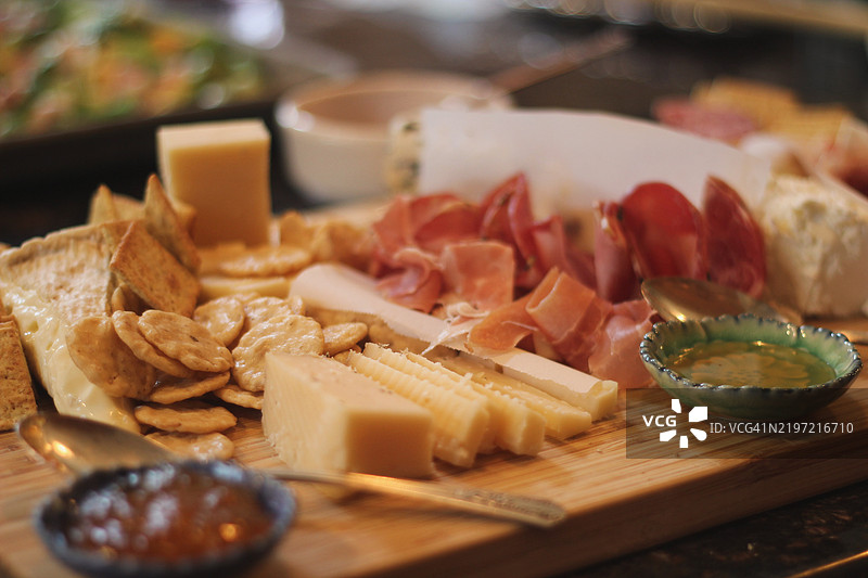 奶酪、肉类和饼干的冷盘拼盘。繁忙的厨房正在为节日餐准备食物。图片素材