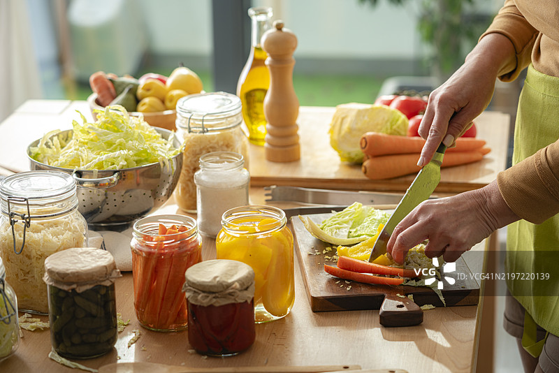 特写镜头下的女性双手正在切割新鲜有机蔬菜。在家腌制健康蔬菜。图片素材