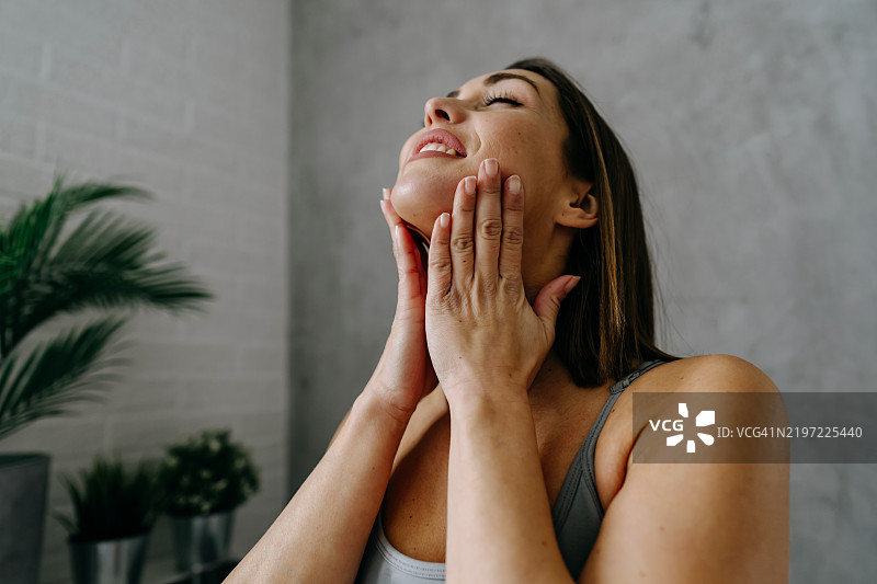 女人享受护肤程序，给自己的脸部按摩图片素材