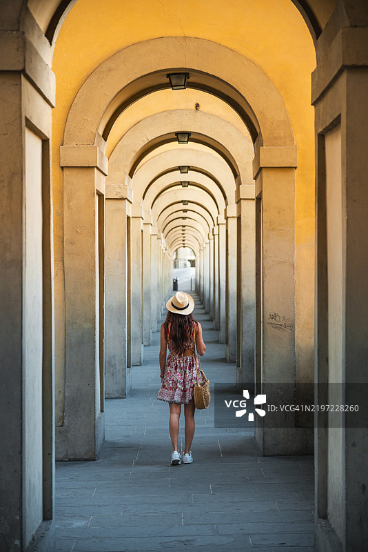 一位女性在意大利佛罗伦萨优雅的拱门通道中探险图片素材