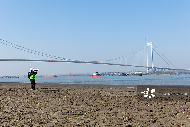 工程师在岸边检查悬索桥图片素材