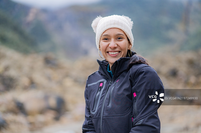 年轻的西班牙裔美国女孩在度假时微笑着在山中玩耍 - 股票照片图片素材