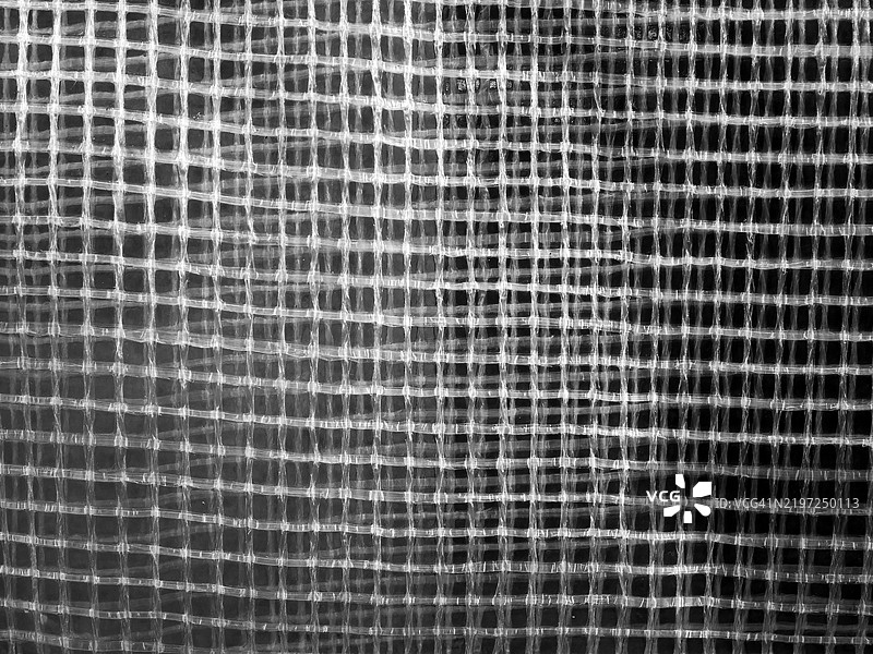 透明波浪状的格子塑料帆布特写。阳光。黑白。法国巴黎。图片素材
