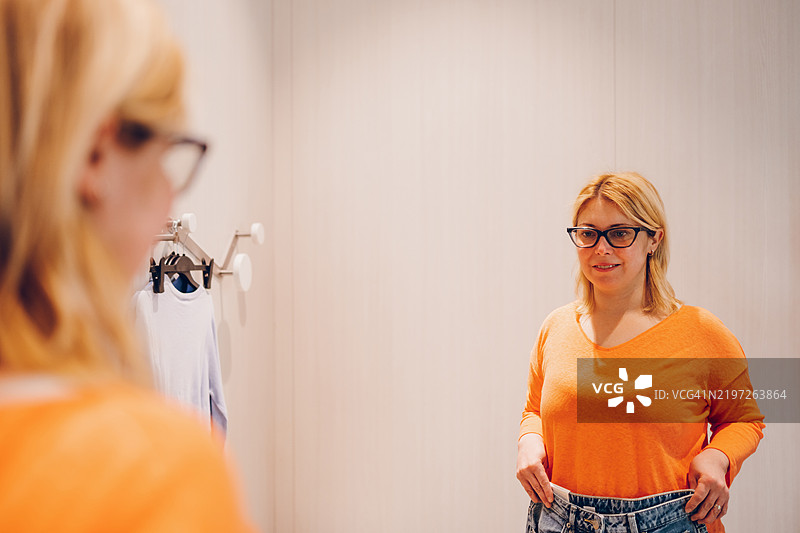 年轻女性在试衣间试衣服图片素材