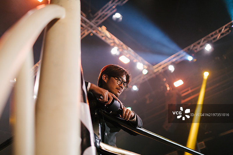 播报员靠在拳击台的绳索上图片素材