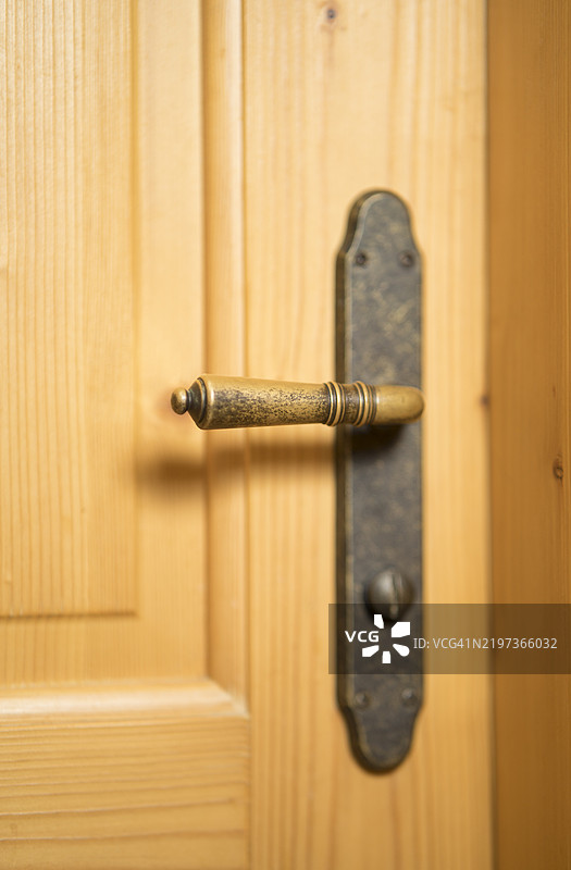 室内木门上的金属门把手图片素材