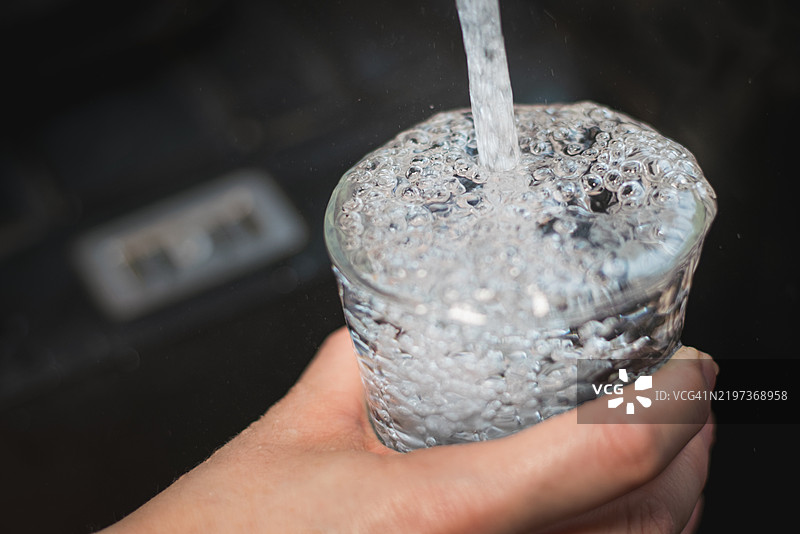 将清水倒入玻璃杯中图片素材
