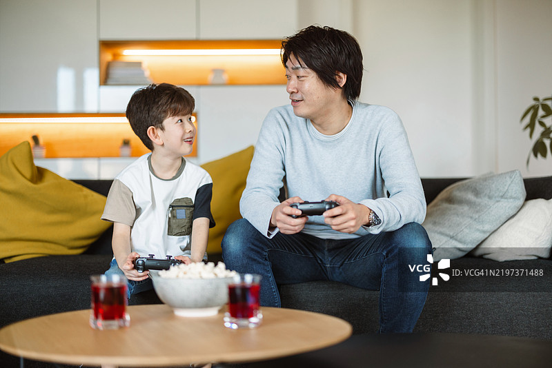 父亲和儿子在家玩视频游戏图片素材