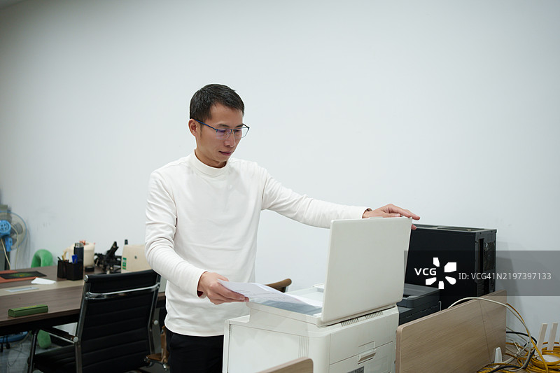 亚洲员工在使用复印机图片素材