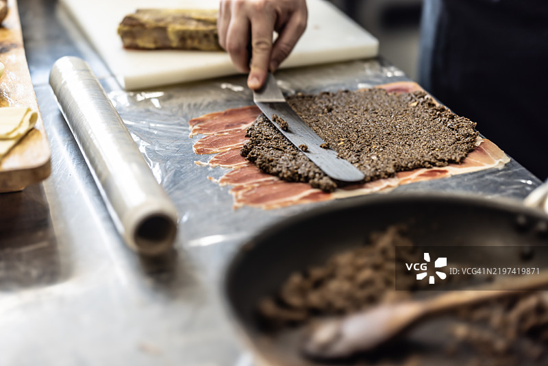 典型的威灵顿牛肉准备过程。分层放置火腿和蘑菇混合物图片素材